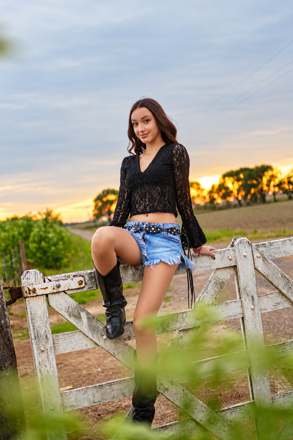 Emilia sentada en una cerca al atardecer